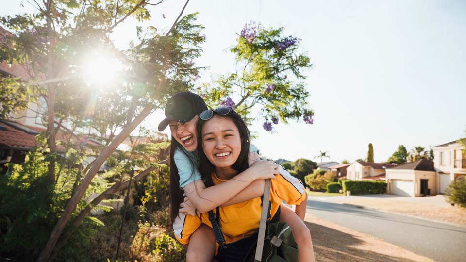 Two young international students laughing and playing together.