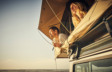 Man and woman looking out of car tent