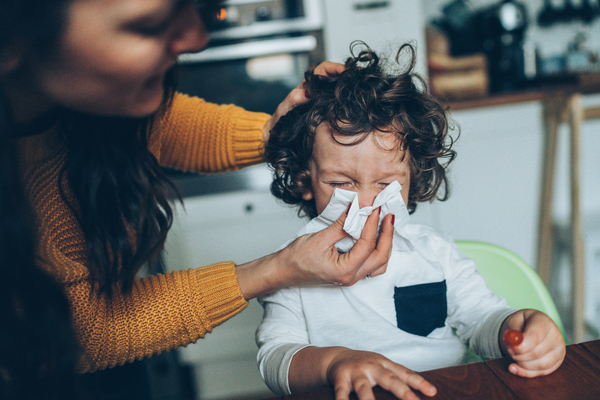 Mother helping son to blow his nose