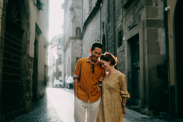 A couple hugging and walking through a European street