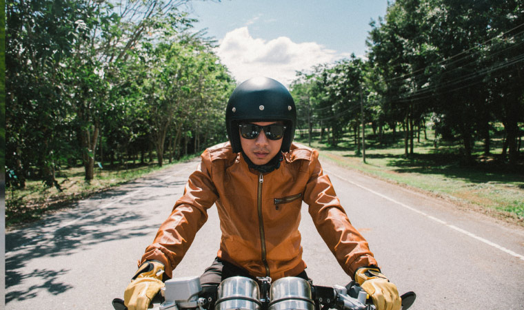 A man riding on a motorbike wearing a helmet