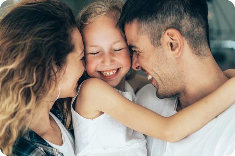 Mother and father embracing their daughter