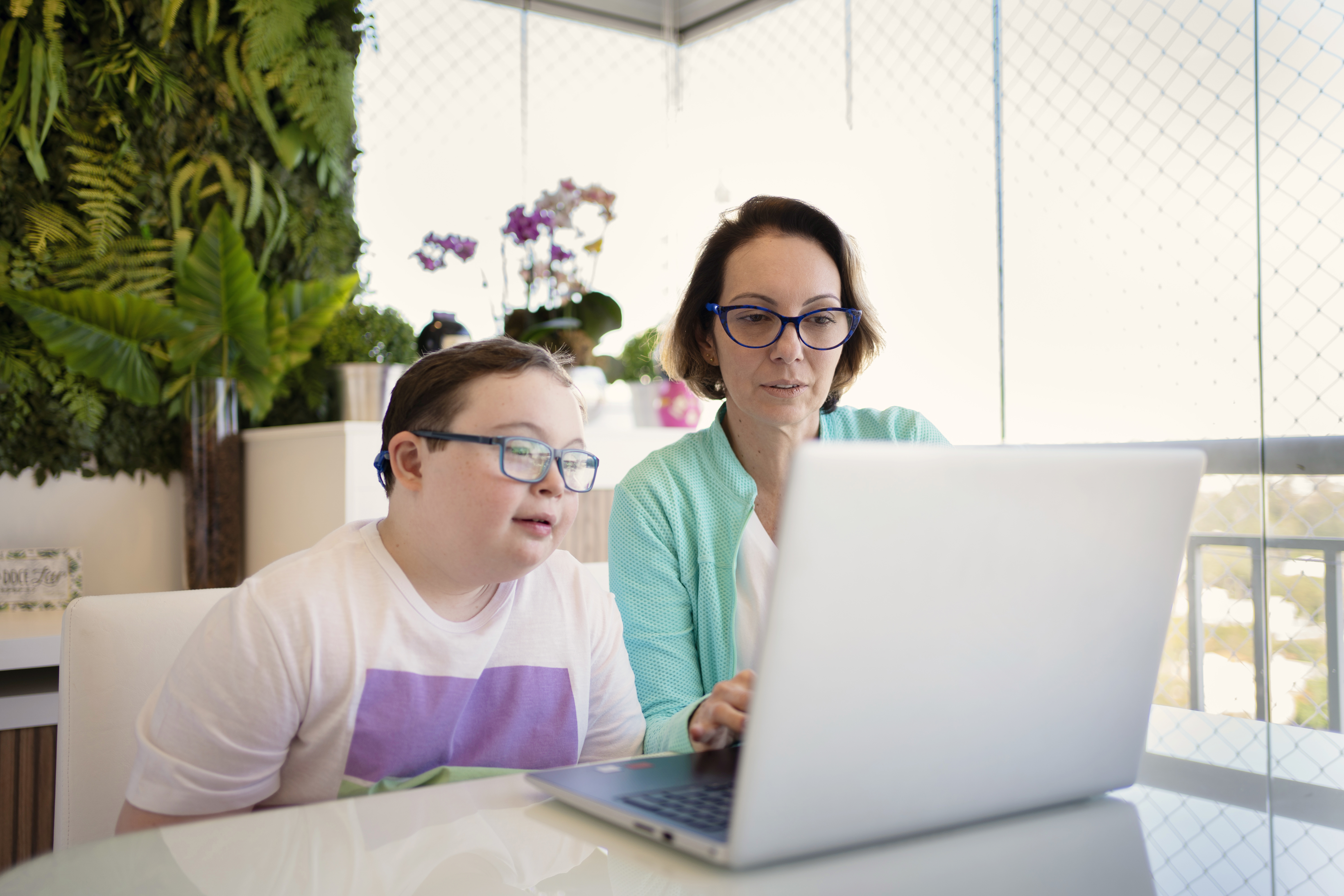 Woman helping boy on the computer.