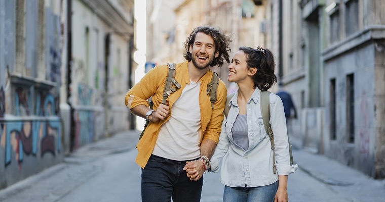 A young couple holding hands in a European city