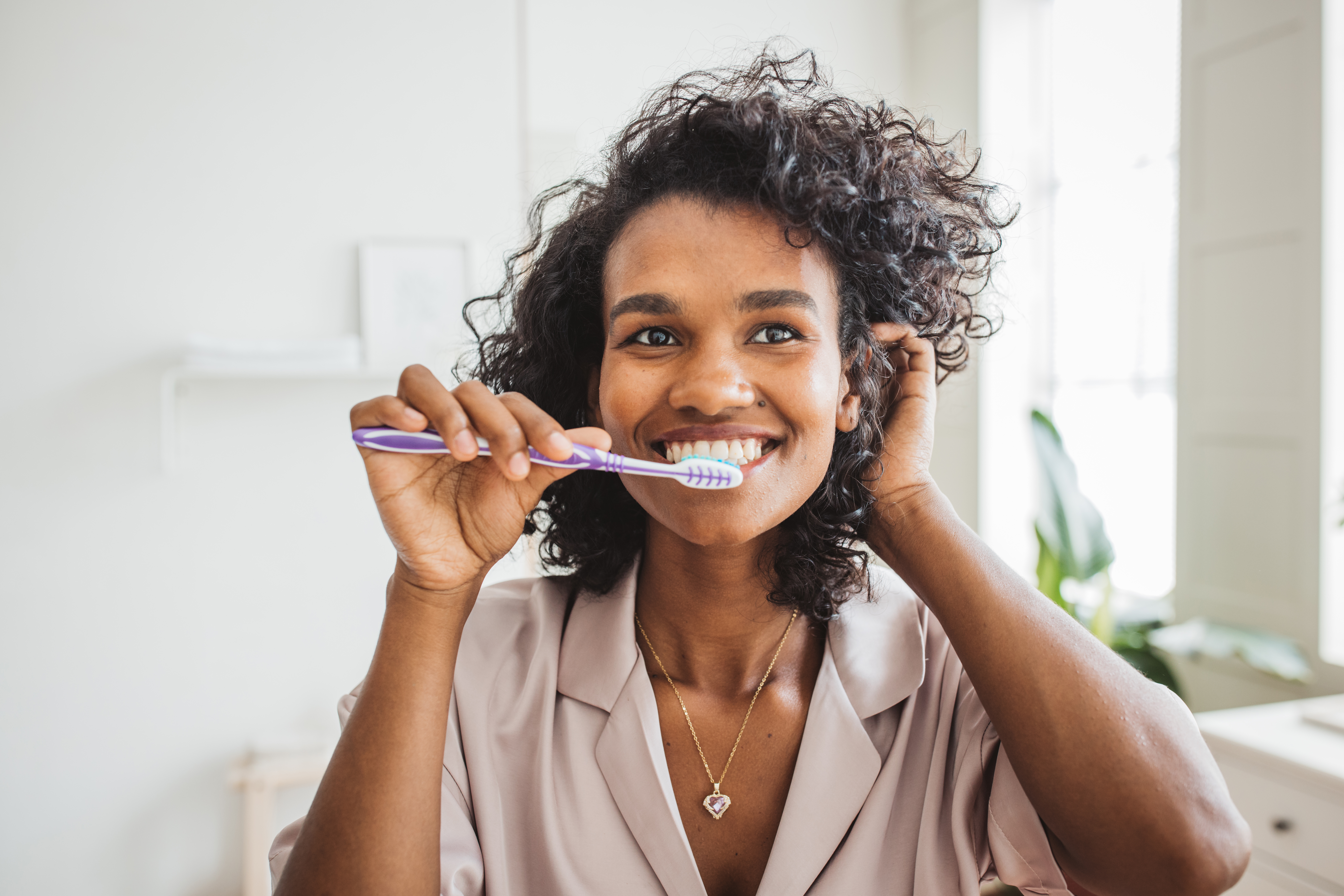 Woman brushing teeth smiling 