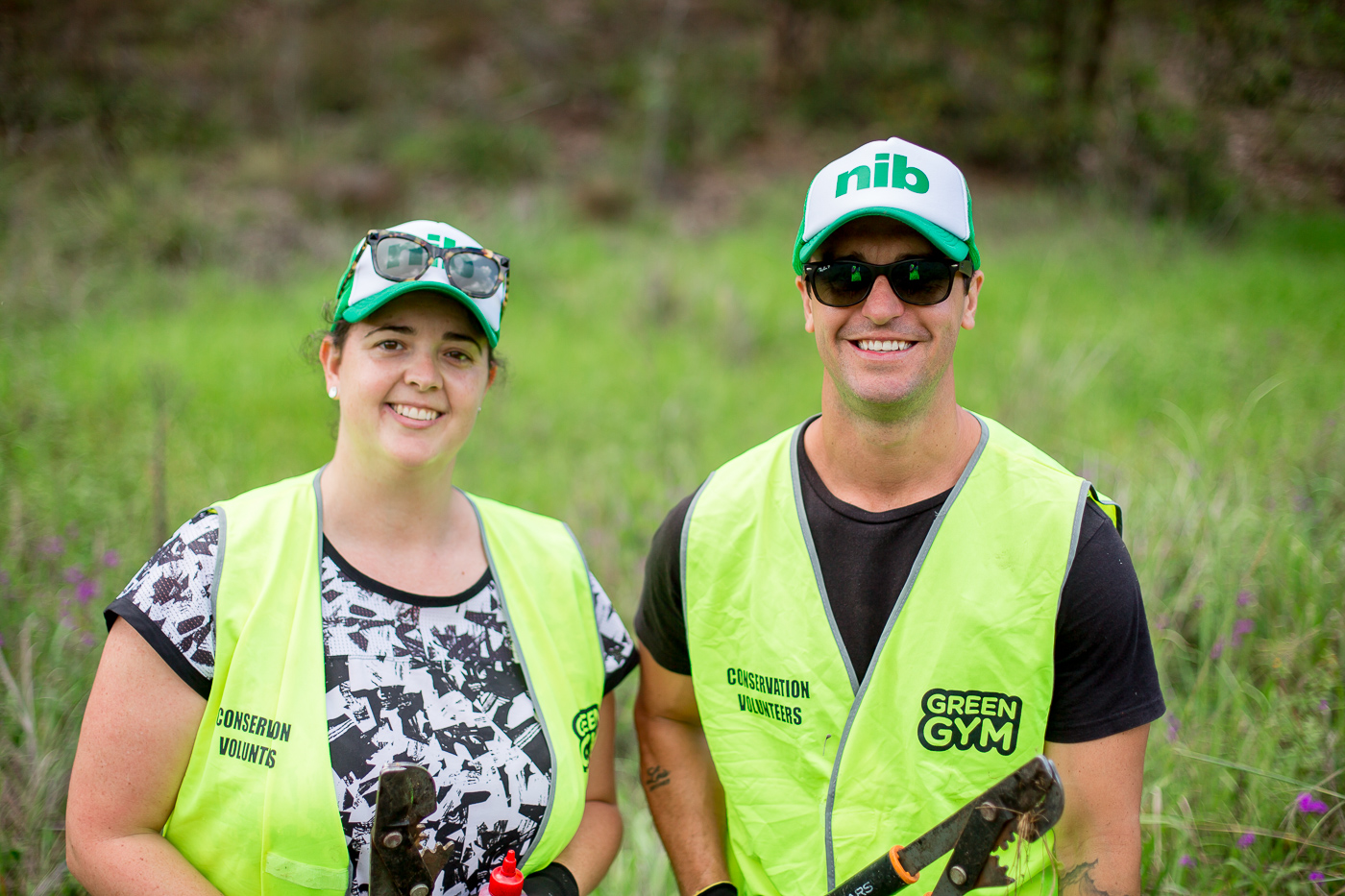 Two nib employees volunteering, wearing hi-vis vests