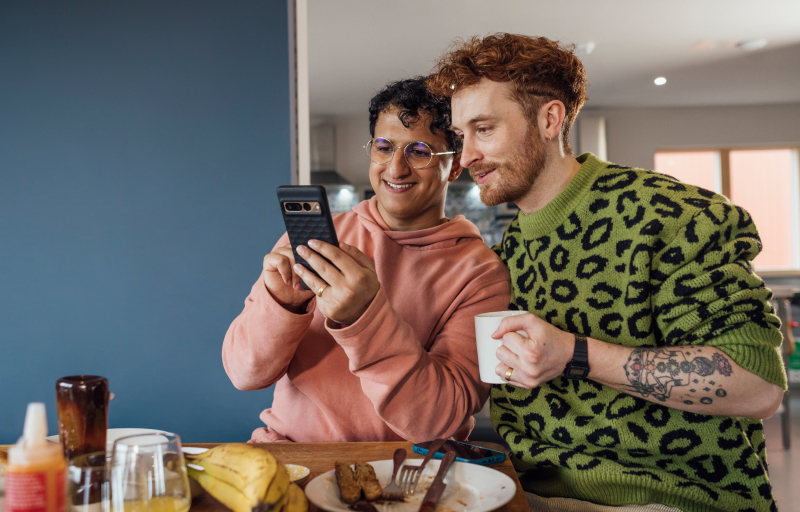 Male couple in a cafe browsing on a phone