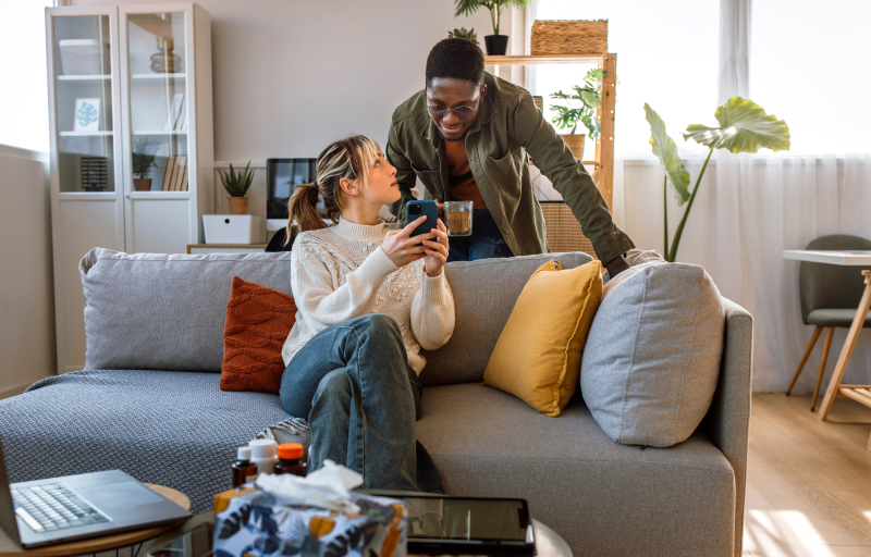 Woman and man couple at home on the couch on a video call on their phone
