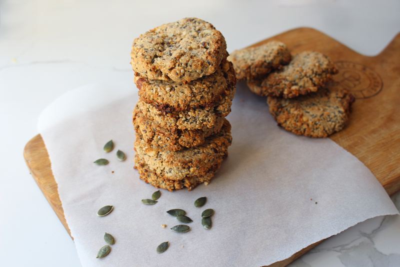 A stack of cookies on a wooden serving paddle.