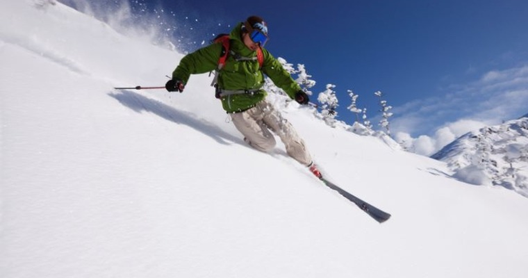 An action shot of a skiier riding down a mountain