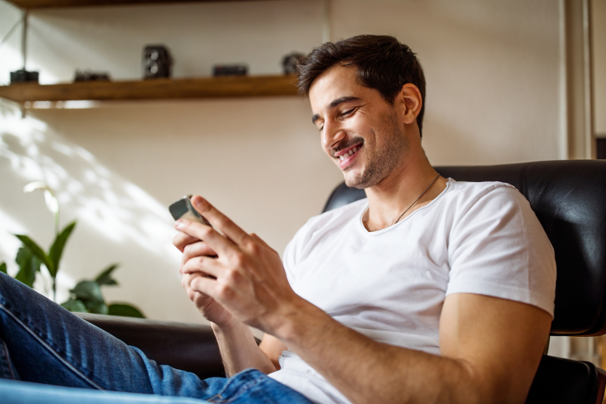Person sitting on a chair and looking at their phone.