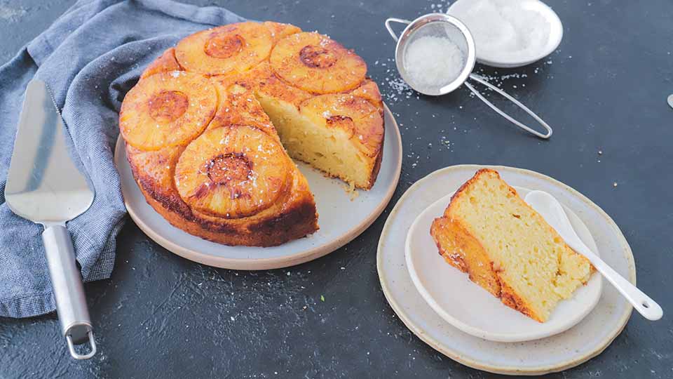 Pineapple upside down cake with a slide taken out of the cake and plated on a saucer.