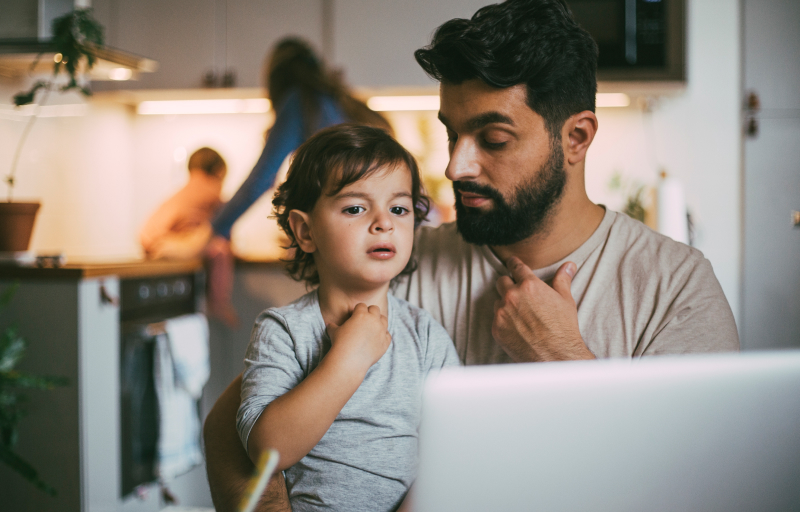 Father and son on a telehealth call on laptop 