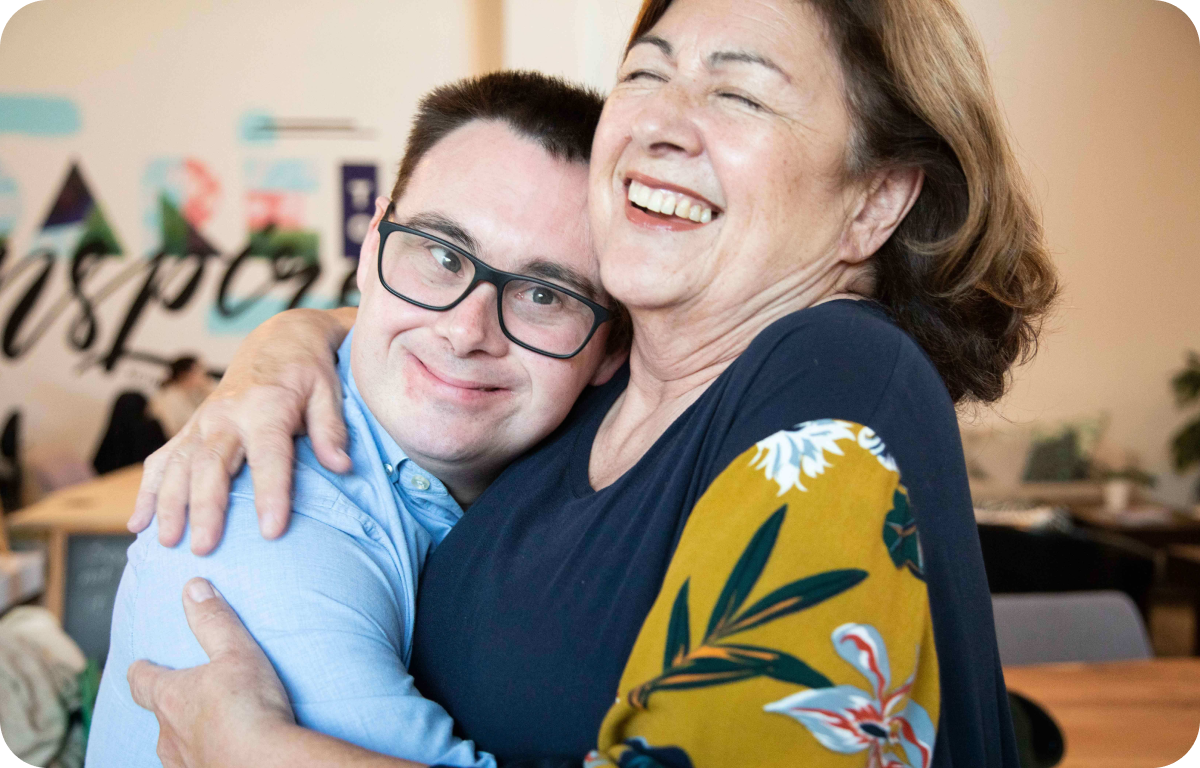 An adult man with down syndrome hugs his mum