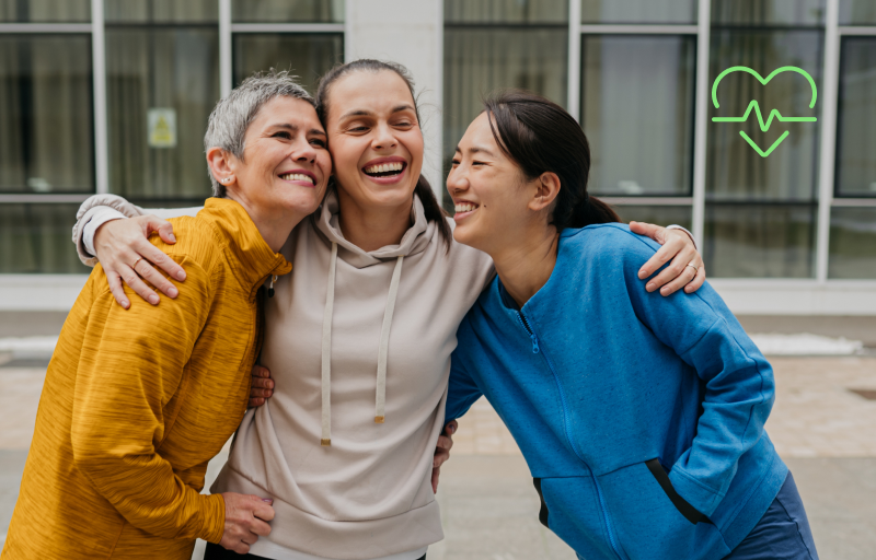 three woman smiling and hugging.