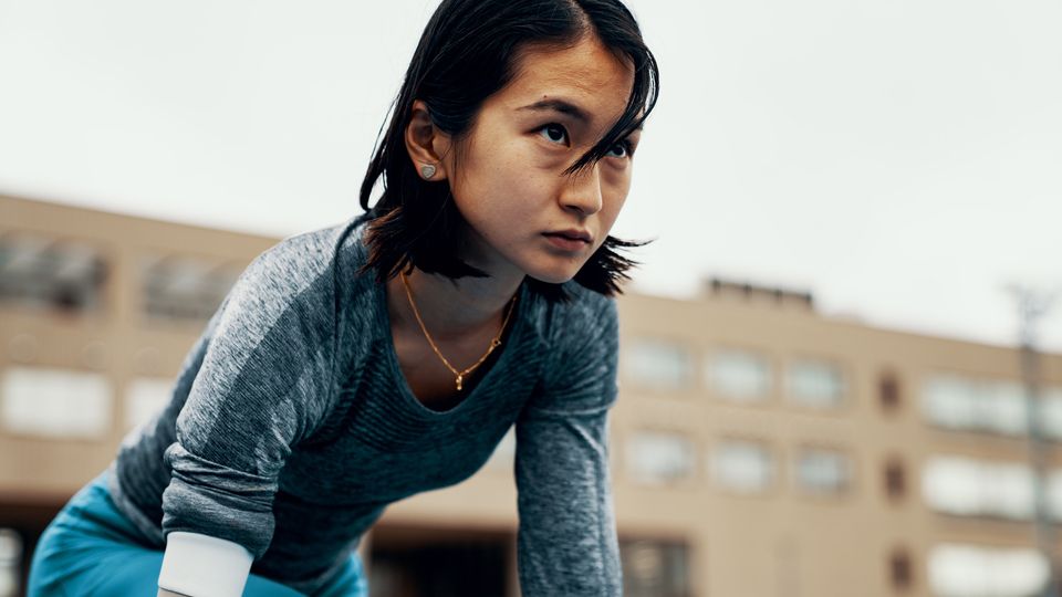 Person in runner's crouch with determined look on their face.