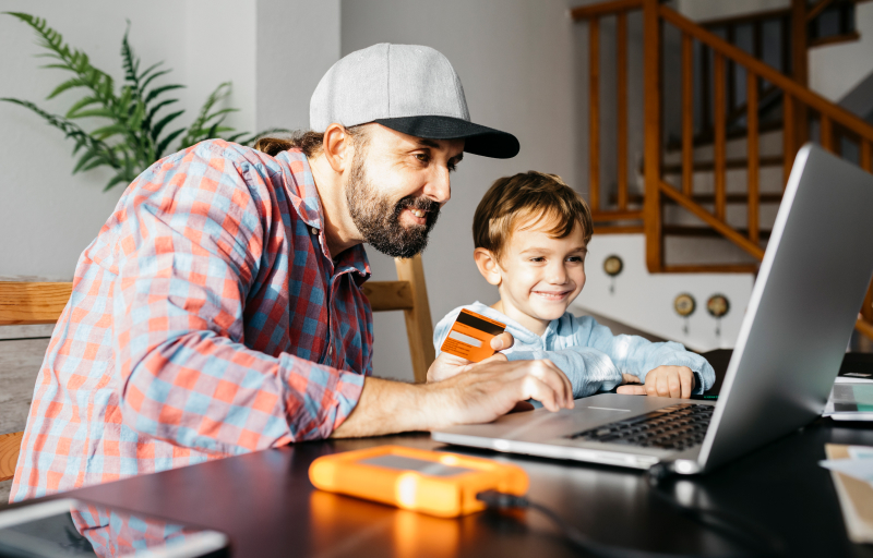 Father and son online shopping together on a laptop