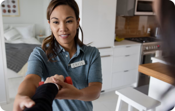 A physio named Chris holds a woman's arm