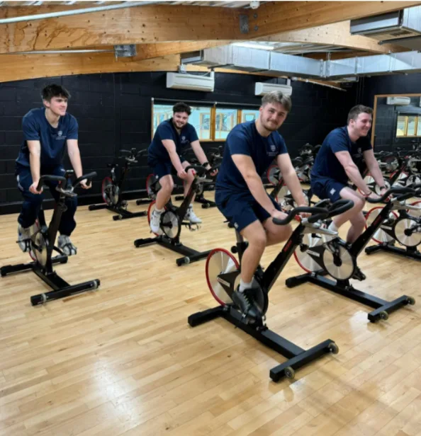 4 men ride exercise bikes at St. Mary's sports clup