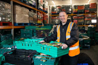 Warehouse worker with crate of food.