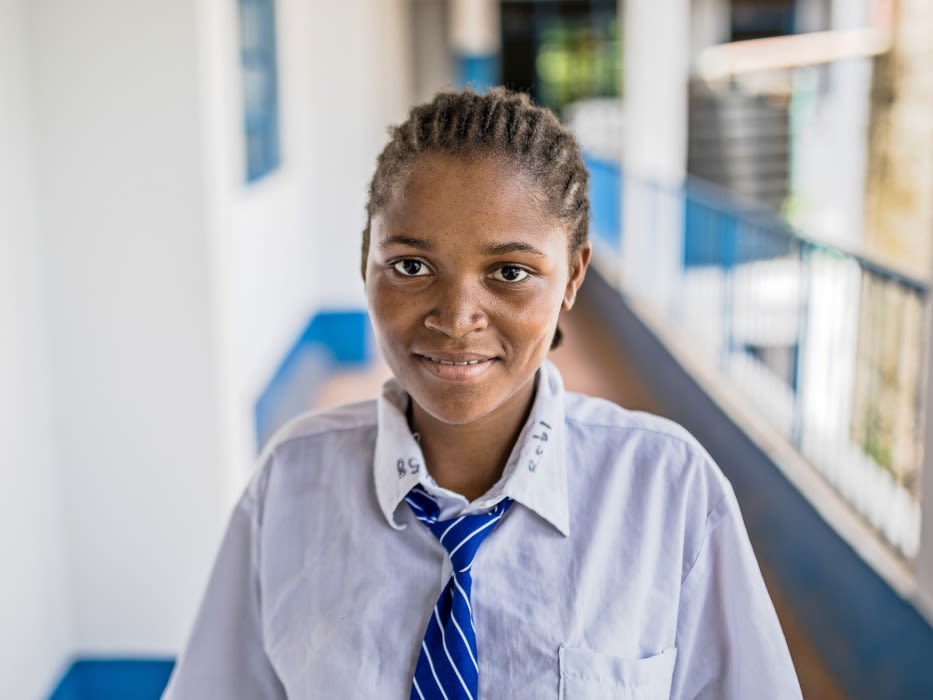 A student standing in an outdoor school hallway