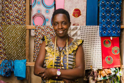 A small business owner standing in front of textiles