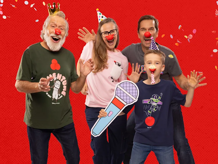 Four people wearing red noses smiling at the camera