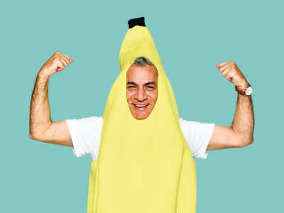 Person dressed as a banana and flexing their arms