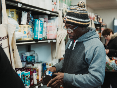 Man in a food bank, holding his wallet