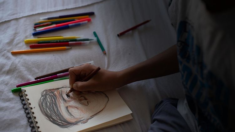 Farhad drawing in his sketchbook