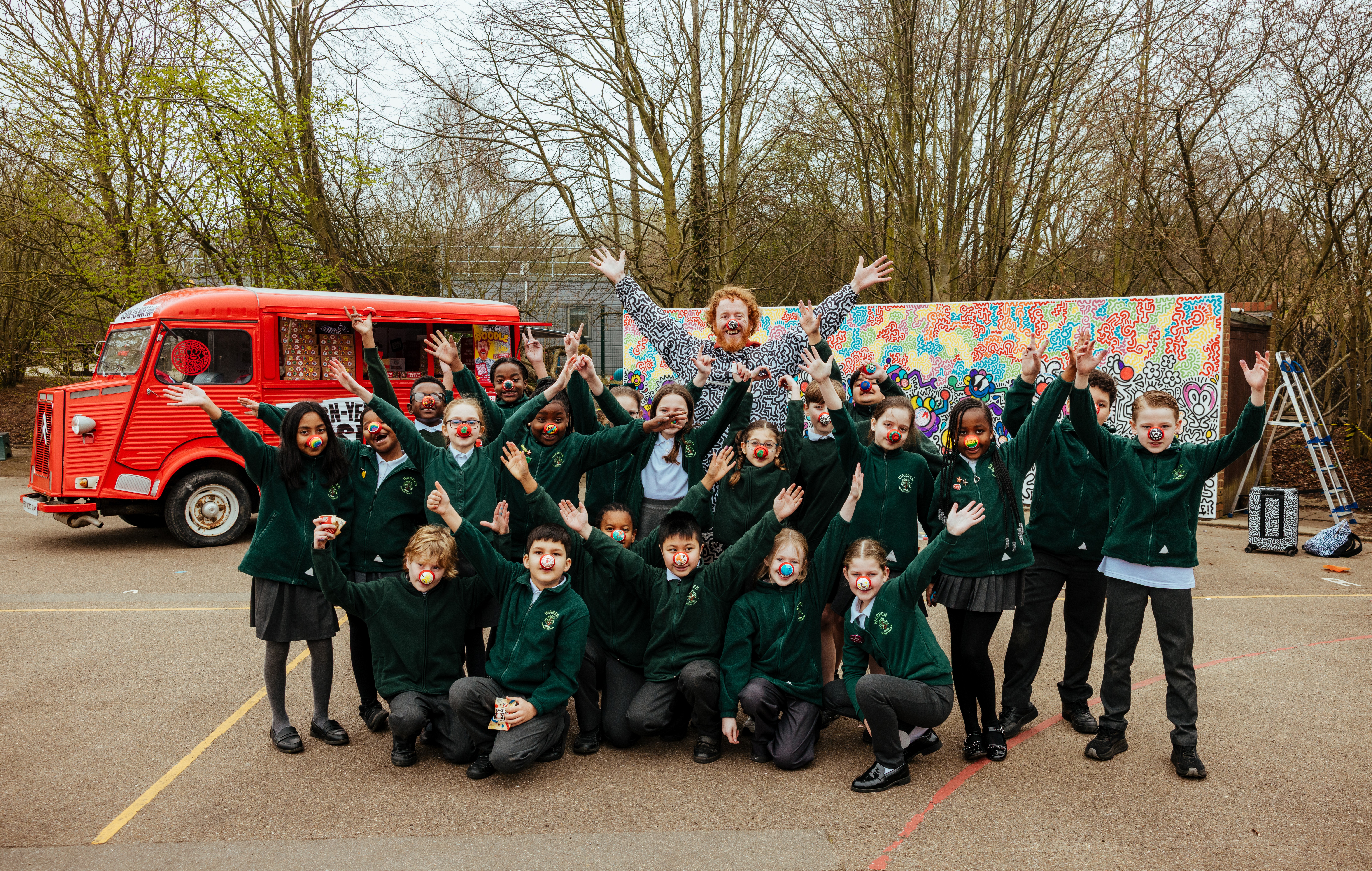 Pupils from Warren primary school join Mr Doodle in front of completed mural