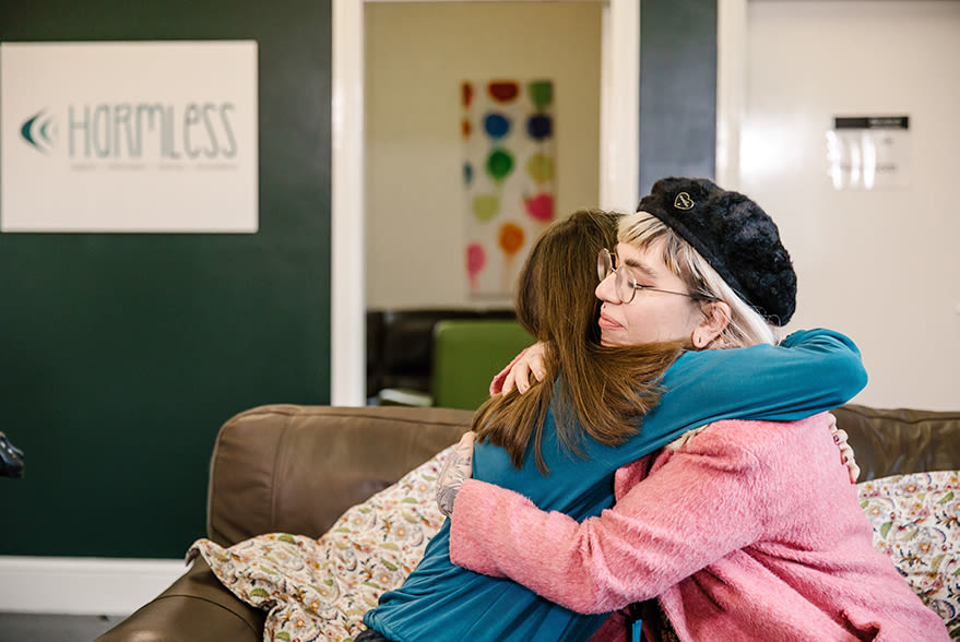 Two people hugging on a sofa