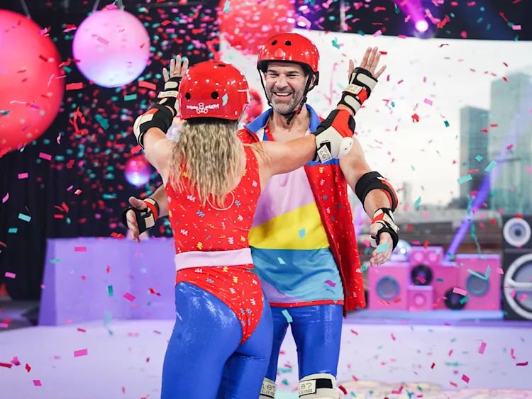 Gethin and Helen completing their Wheely Big Challenge, with confetti falling around them