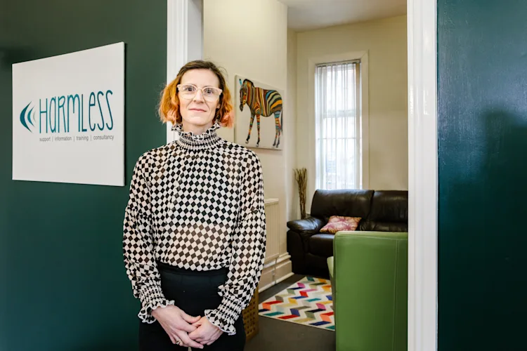 A counsellor for Harmless stands in front of their office.