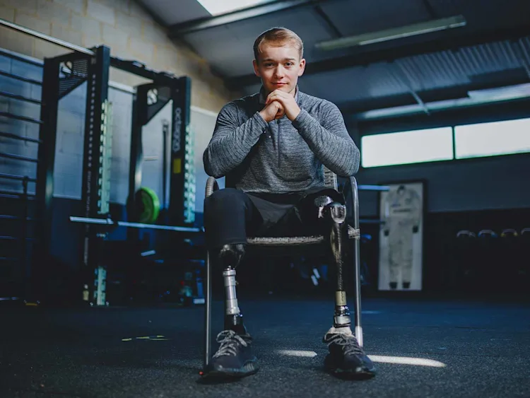 Billy sitting on a chair in the gym looking at the camera.