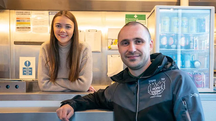 Courtney and Ritchie smiling in their food truck.