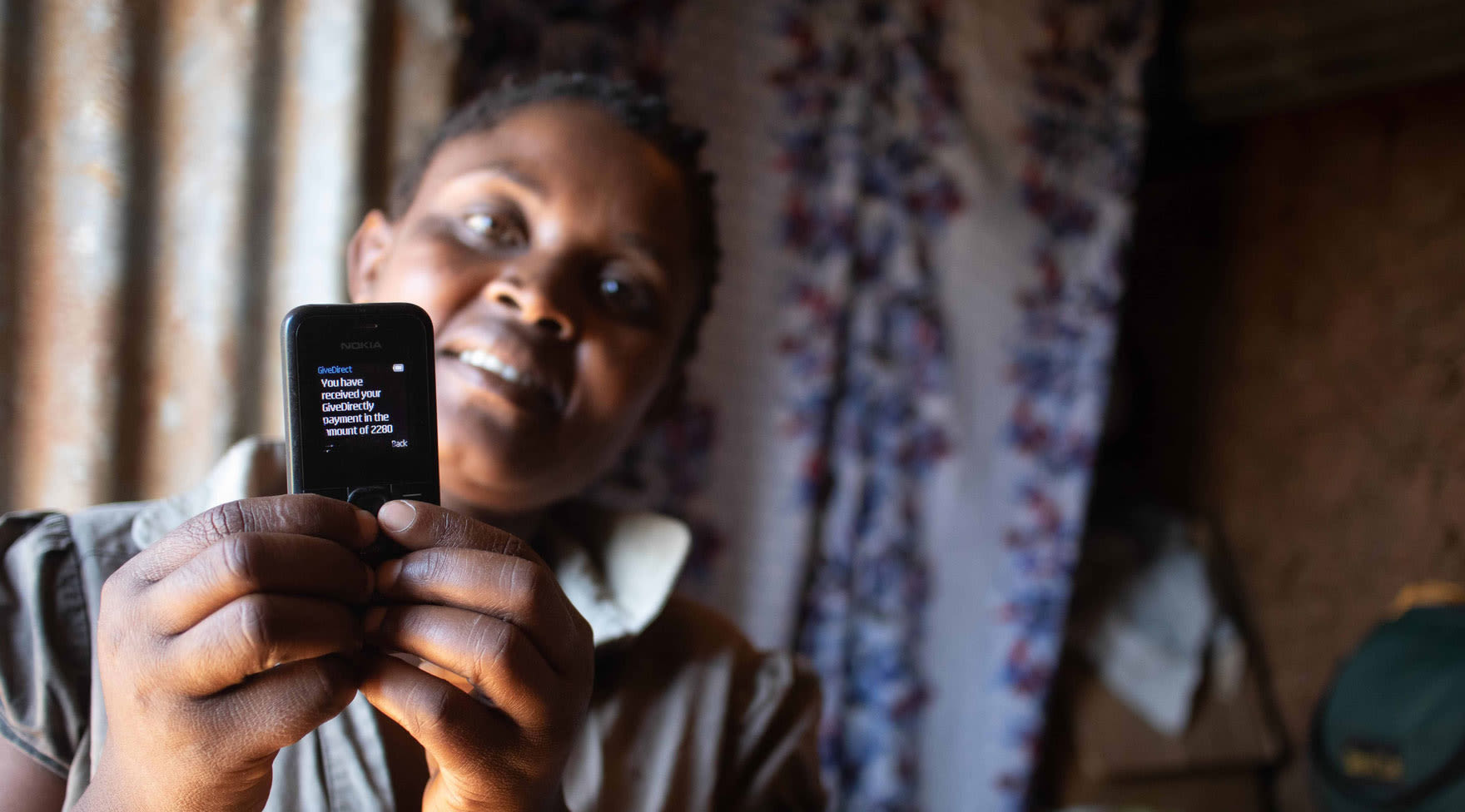 Jackline O demonstrates the service on her phone