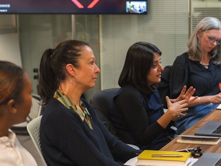 A group of people in a discussion sitting around a table