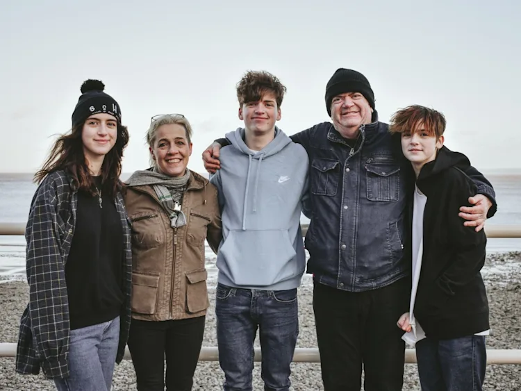 Kate shares a laugh with her family on a beach.