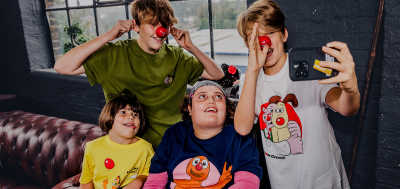 A group of four children enjoy themselves and goof around while wearing Comic Relief merchandise for Red Nose Day 2024.