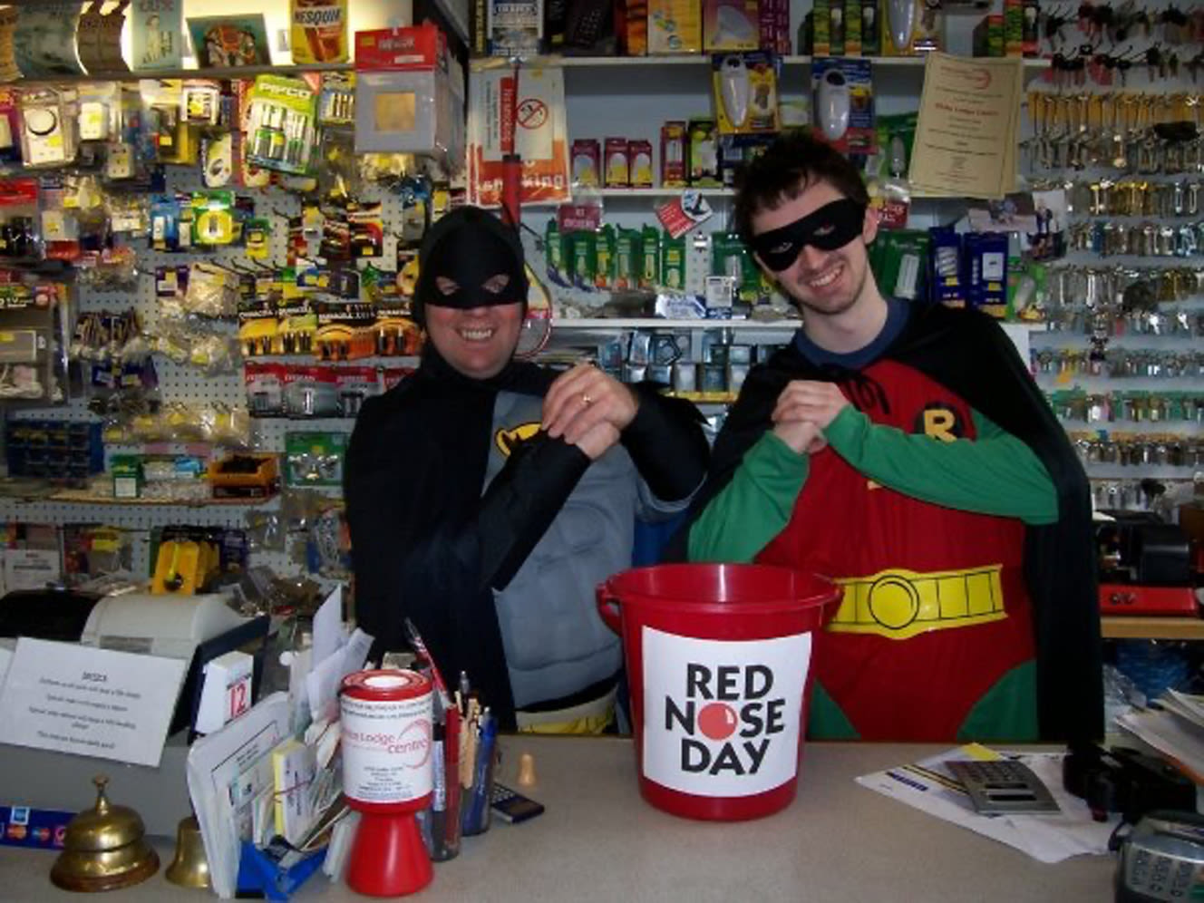 Two fundraisers at a hardware shop dressed as Batman and Robin