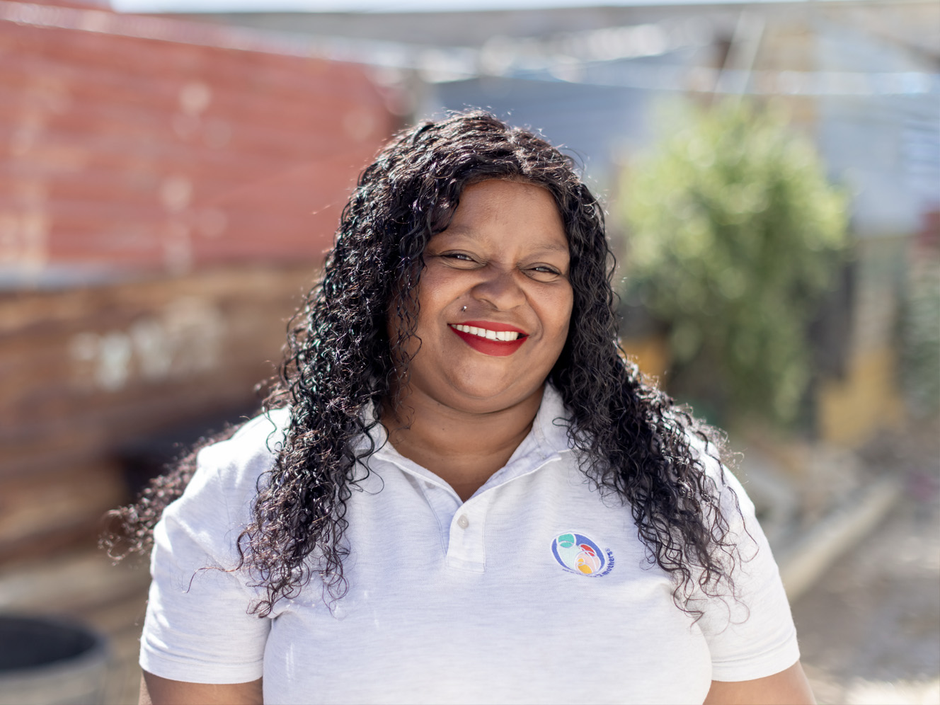Millicent, a mentor at mothers2mothers, smiling at the camera