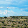 Southwestern landscape with wind turbines and gas beacons