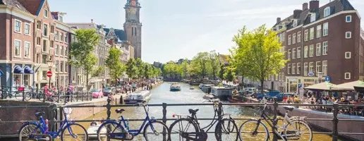Amsterdam vanaf een brug met fietsen en uitzicht op de gracht