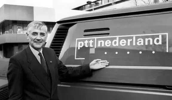 Man (Wim Dik)  naast bedrijfsauto met logo PTT Nederland erop