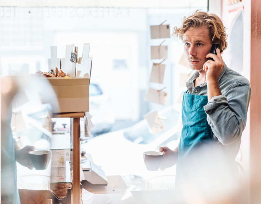 Barista aan de telefoon in een koffiezaak