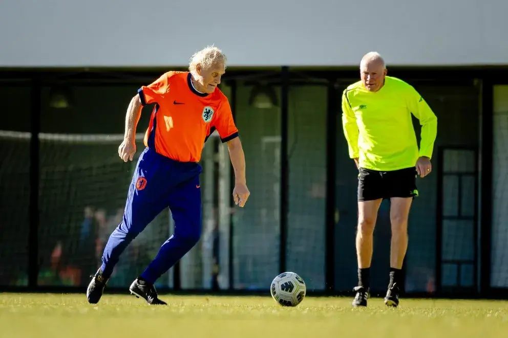 Twee spelers op voetbalveld bij een voetbal