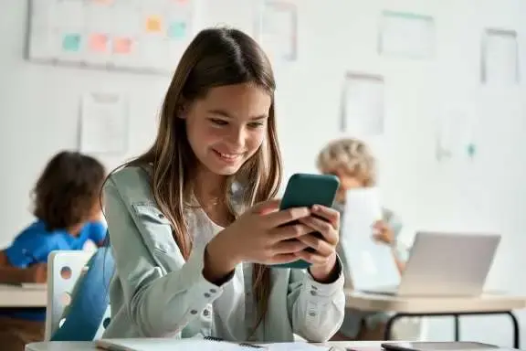 Meisje in de klas kijkt op telefoon