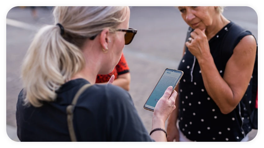 2 vrouwen kijken samen naar een mobiele telefoon