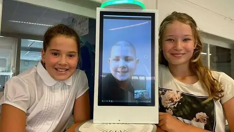 twee klasgenootjes zitten naast de KPN klasgenoot met online hun zieke klasgenootje